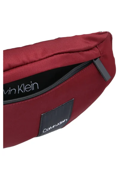 torbica za okoli pasu item story Calvin Klein 	bordo	